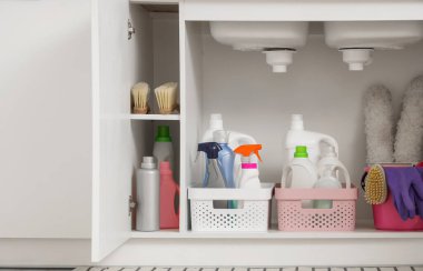 Mutfakta farklı temizlik malzemeleri, fırçalar, lastik eldivenler ve pp-tozluk sepetleri olan bir çekmece aç.