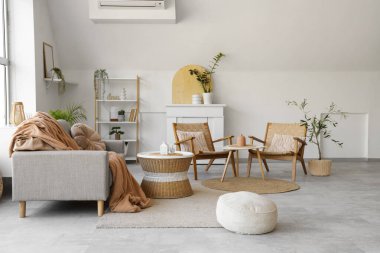 Rahat gri kanepesi, kahve masası, puf ve çiçekleri olan şık bir oturma odası.