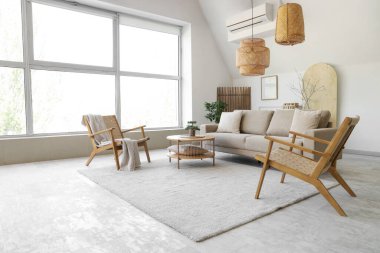 Rahat gri kanepesi, sehpası ve koltukları olan şık bir oturma odası.