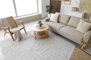 Rahat gri kanepesi, sehpası ve koltukları olan şık bir oturma odası.