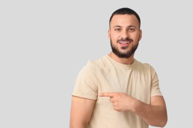 Hafif arka planda uygulamalı tıbbi yaması olan genç bir adam. Dokunulmazlık kavramı