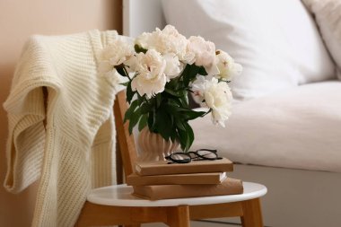 Şakayık çiçekli vazo, gözlük ve kitap yatak odasındaydı.