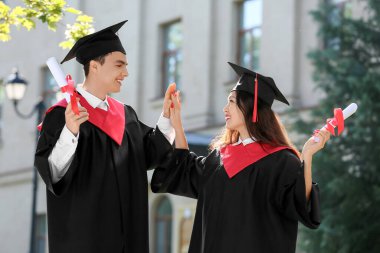 Mezuniyet gününde diploması olan birkaç mutlu öğrenci.