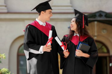 Mezuniyet gününde diploma ve kitapları olan birkaç mutlu öğrenci.