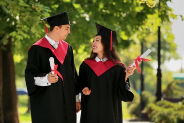 Dışarıda diploması olan birkaç mutlu mezun öğrenci.