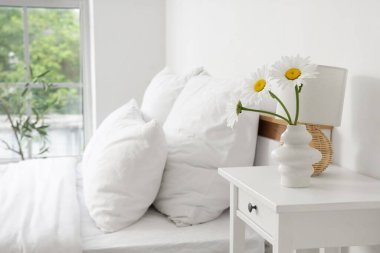 Vazo papatya çayı ve lamba yatak odasındaki masada.