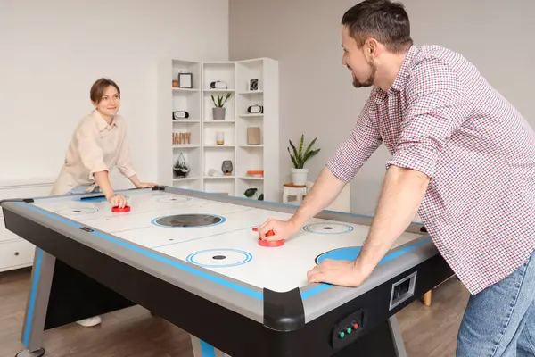 Evde hokey oynayan genç bir çift.