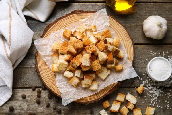 Tahtada kıtır kıtır ekmek ve ahşap arka planda farklı baharatlar var.