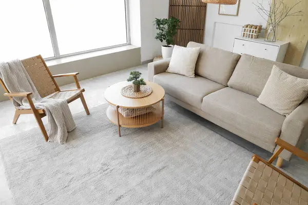 Rahat gri kanepesi, sehpası ve koltukları olan şık bir oturma odası.