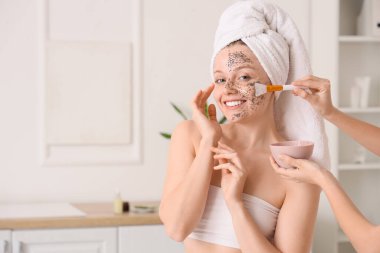 Güzellik salonunda chia tohumu maskesi alan mutlu genç bir kadın.