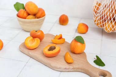 Beyaz fayans masasında taze kayısı ve kâse.