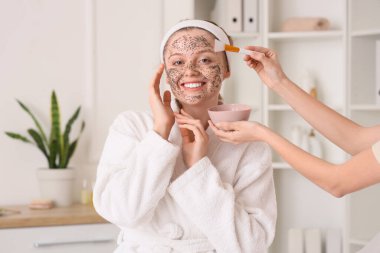 Güzellik salonunda chia tohumu maskesi alan mutlu genç bir kadın.