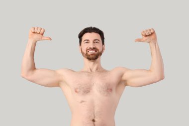 Gri arka planda kendini gösteren mutlu sakallı adam. Vücut pozitif konsept