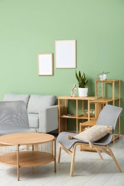 Renk duvarında boş resim çerçeveleri olan modern oturma odasının şık iç tasarımı