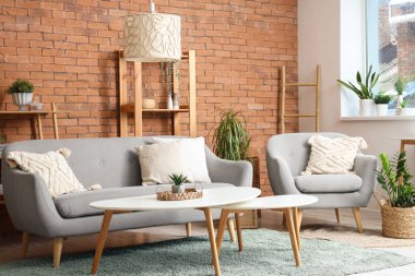 Oturma odasının içinde koltuk, kanepe ve çiçek var.