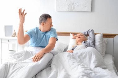 Yatak odasında horlayan karısı olan, olgunlaşmamış bir adam.