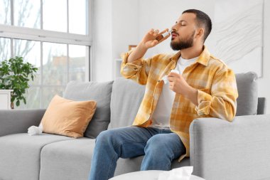 Evde alerji yüzünden burun damlası kullanan dokuları olan hasta genç bir adam.