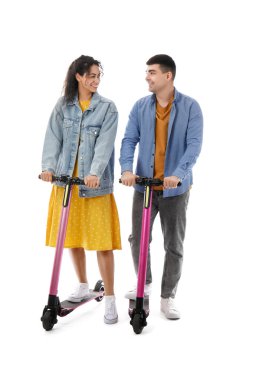 Beyaz arka planda modern elektrikli scooter kullanan güzel bir çift.