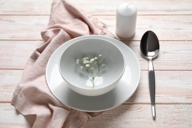 Mum ve çigila çiçekli güzel masa ayarları. Renkli ahşap arka plan, yakın plan.