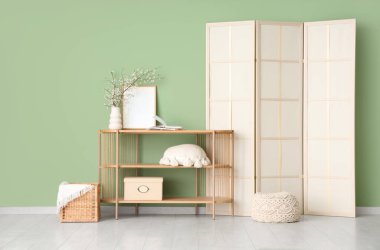 Katlanmış perdeli, ağaç dalları ahşap masa üzerinde şık bir oda.