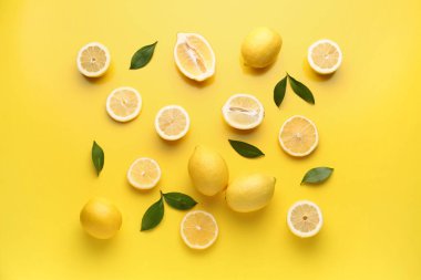 Composition with fresh lemons on yellow background