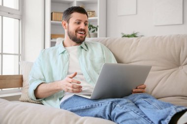 Evdeki kanepede dizüstü bilgisayar kullanmasına şaşırdım.