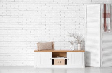 Kabinesinde katlanan ekran ve çiçek açan ağaç dalları olan şık bir odanın içinde.