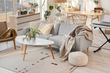 Kanepesi, bitkileri ve sentezleyicisi olan bir oturma odası.