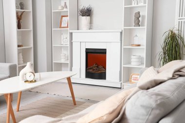 Oturma odasında raf üniteleri ve kanepesi olan modern şömine.