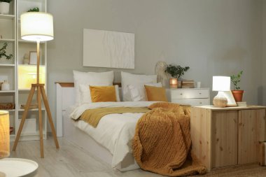 Şık bir yatak odası, yatak odası, raf üniteleri, tuvaletler ve akşam lambaları.