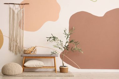 Yastıklı, yumuşak gri bir bank ve odada puf.