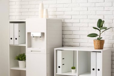 Modern su soğutuculu ve raf üniteli hafif bir ofis.