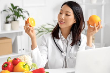 Ofiste portakallı Asyalı kadın beslenme uzmanı.