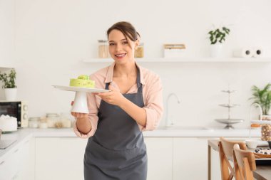 Mutfakta lezzetli pastası olan bir kadın pastacı.