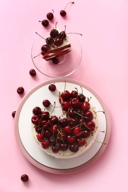 Pembe arka planda lezzetli vişneli kek tabakları