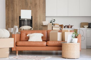 Taşındığı gün mutfakta karton kutularla dolu bir kanepe.