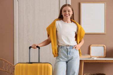 Güzel genç bayan valiziyle salona yakın bir yerde.