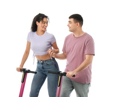 Beyaz arka planda modern elektrikli scooterları olan güzel genç bir çift.