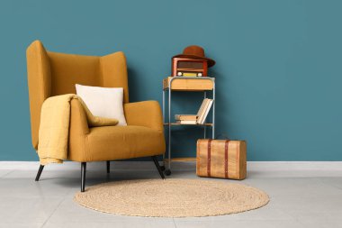 Oturma odası, koltuk, retro radyo alıcısı ve bavul.