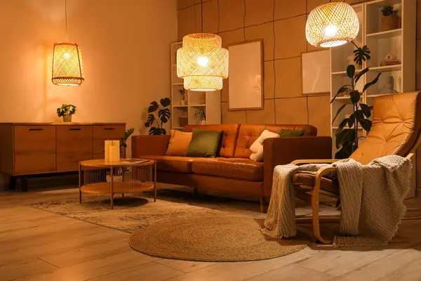 Kahverengi kanepesi, sehpası ve akşam lambaları olan şık bir oturma odası.
