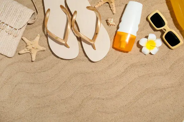 Arka planda plaj aksesuarları, deniz yıldızları ve güneş kremi olan yaz çantası.