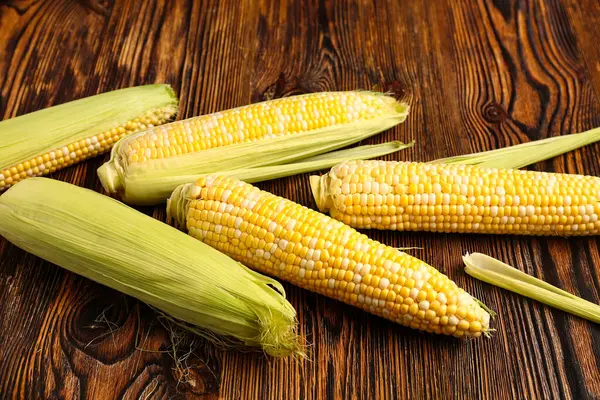 Tahta arka planda taze mısır koçanları