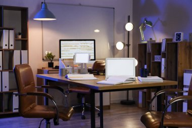 Tablet bilgisayarlı boş dizüstü bilgisayar ve geceleri ofisteki not defterleri.