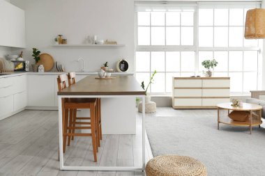 Mutfağın içi masa, tezgah ve bitkilerle dolu.