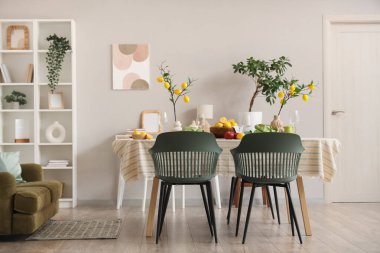 Yemek odasının içi. Masa düzeneği, taze limon ağaçları ve limon dallarıyla dolu.