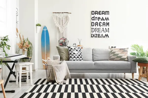 Sörf tahtası, sentezleyici ve kanepesi olan şık bir oturma odası.