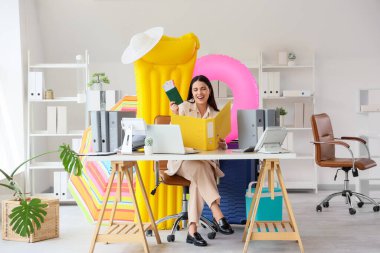 Tatilden önce plaj aksesuarları, pasaport ve biletleri olan mutlu iş kadını.