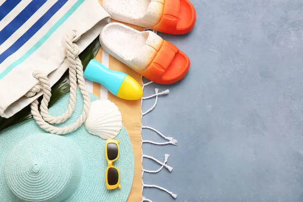 Mavi grunge arka planında güneş kremi ve plaj aksesuarları olan kompozisyon
