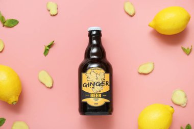 Pembe arka planda taze zencefilli bira, limon ve naneli kompozisyon