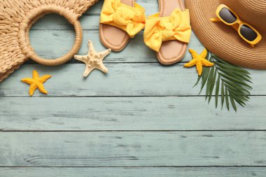 Yeşil ahşap arka planda deniz yıldızları ve plaj aksesuarlarıyla kompozisyon